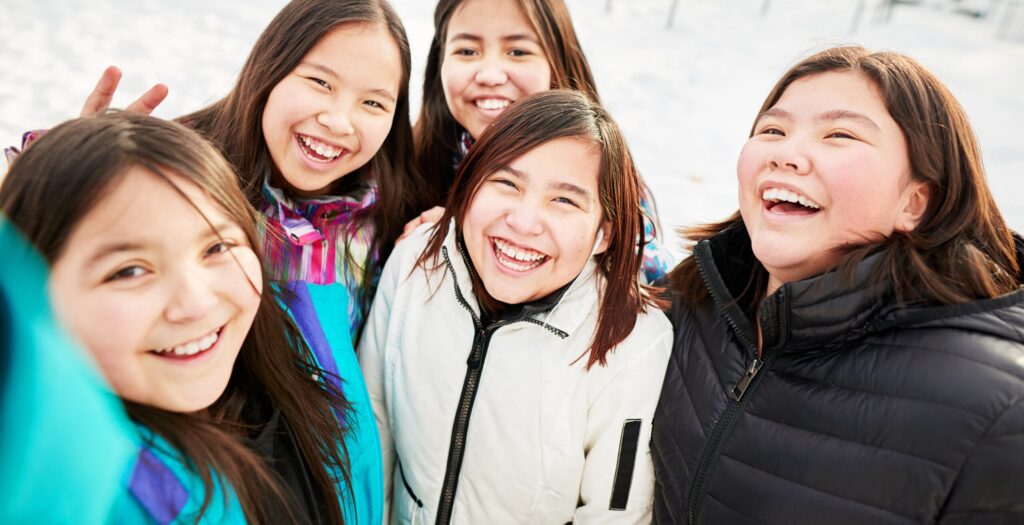 Group of girls taking selfie at school field on a winter day - RHS Grants
